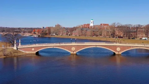 Aerial over the John W. Weeks Footbridge reveals Harvard University campus on Stock Footage 113402813