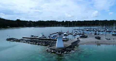 Aerial Over Lighthouse Of Small Boat Harbor In Northern Lake On Overcast Day Stock Footage 200064589