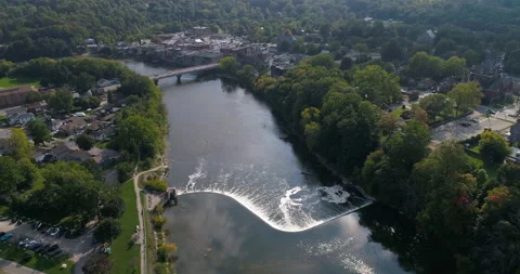 Aerial Over Nice River Shaped Dam Waterfalls Flowing Through The Town Valley Stock Footage 200829496