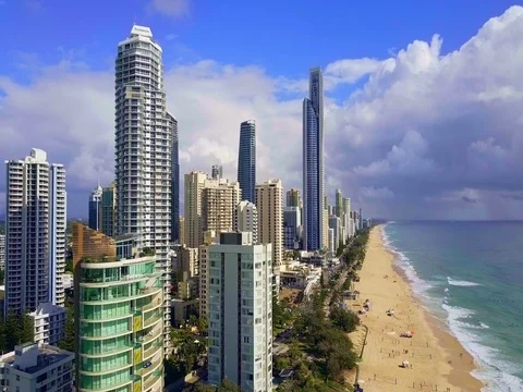 Aerial over ocean surf into the beach of Surfers Paradise Gold Coast Stock Footage