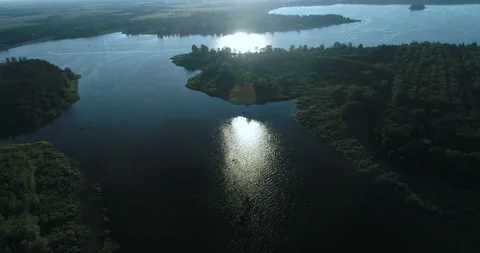 Aerial Over Pristine Lake Setting Sun Reflects Light On Water Then Disappears Video stock 187942022