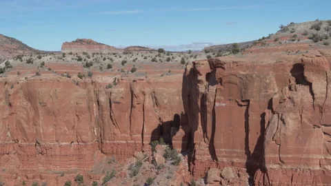 Aerial over red rock cliffs in New Mexico revealing horizon over red butte Vidéo 233768679