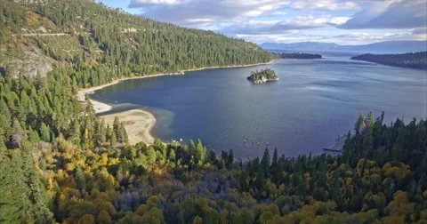 Aerial over shoreline and trees at Lake Tahoe emerald bay Stock Footage