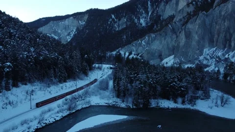 Aerial over Swiss red train in Rhine river canyon in Swiss Alps Stock Footage