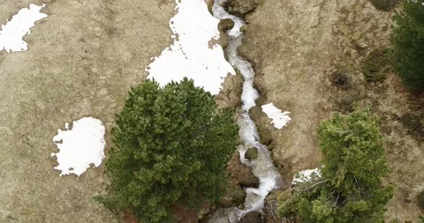 Aerial over treetops and flowing water. Stream in the mountains in spring 4K Video stock 132120341
