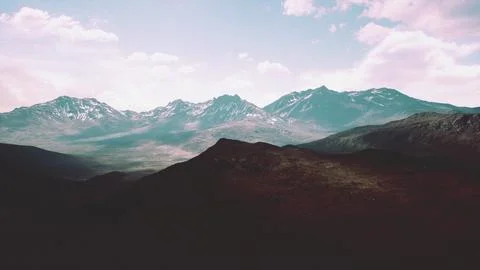 Aerial Over Valley With Snow Capped Mountains In Distance Ilustração Stock