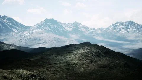 Aerial Over Valley With Snow Capped Mountains In Distance Ilustração Stock