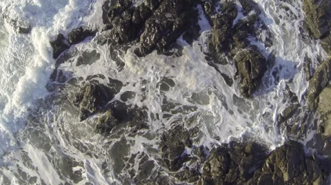 Aerial over waves breaking over rocks. Stock Footage 67367618