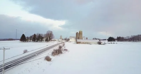 An aerial over wind generation turbines in a snowy landscape. Stock Footage 75696201