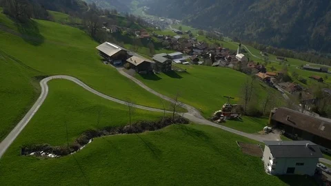Aerial of overhead cable car passing over the houses on rolling landscape Stock Footage 76006060