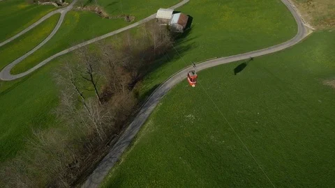 Aerial of overhead cable car passing over the rolling landscape Stock Footage 76006093
