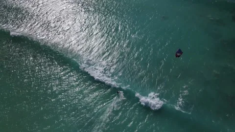 Aerial overhead flight showing kite surfer surfing on clear Pacific Video stock 150221979
