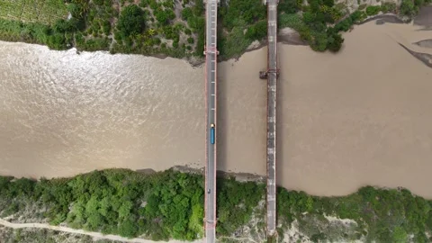 Aerial overhead of parallel bridges over muddy brown river. Stockbeeldmateriaal 333864973
