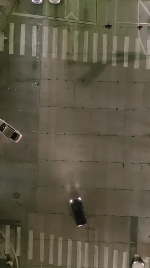 AERIAL: Overhead Rising on Intersection Street at Night with Glowing Streets and Stock Footage 337413330