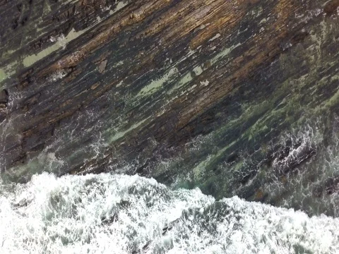 Aerial Overhead Shot of Waves Rolling Over Diagonal Lined Rocks Video stock 80445853