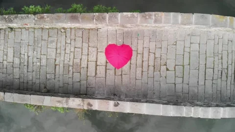 Aerial overhead view of Devils Bridge, Lucca. Red heart shape umbrella on t.. Video stock 334519262