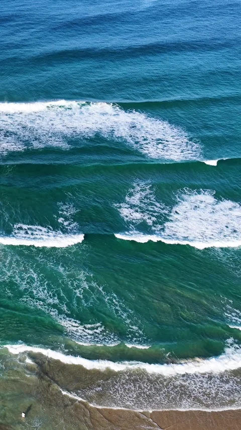 Aerial Overhead View of Ocean Waves Breaking on Sandy Beach Stock Footage 345477620