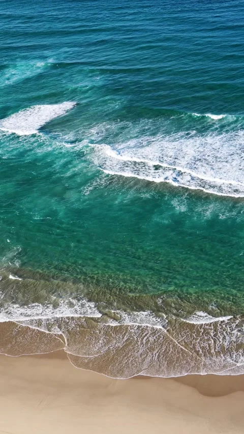 Aerial Overhead View of Ocean Waves Breaking on Sandy Beach Shoreline Stock Footage 345486620