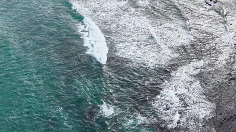 Aerial Overhead View of Turquoise Ocean Waves Crashing on Rocky Coastline Stock Footage 345020695