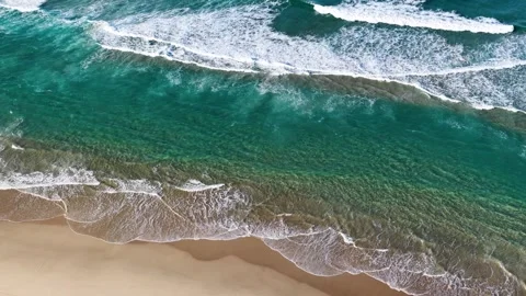 Aerial Overhead View of Turquoise Ocean Waves Crashing on Sandy Beach Stock Footage 345477626