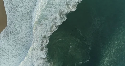 Aerial overhead of waves breaking on Atlantic coast beach, Nazaré Stock Footage 122983818