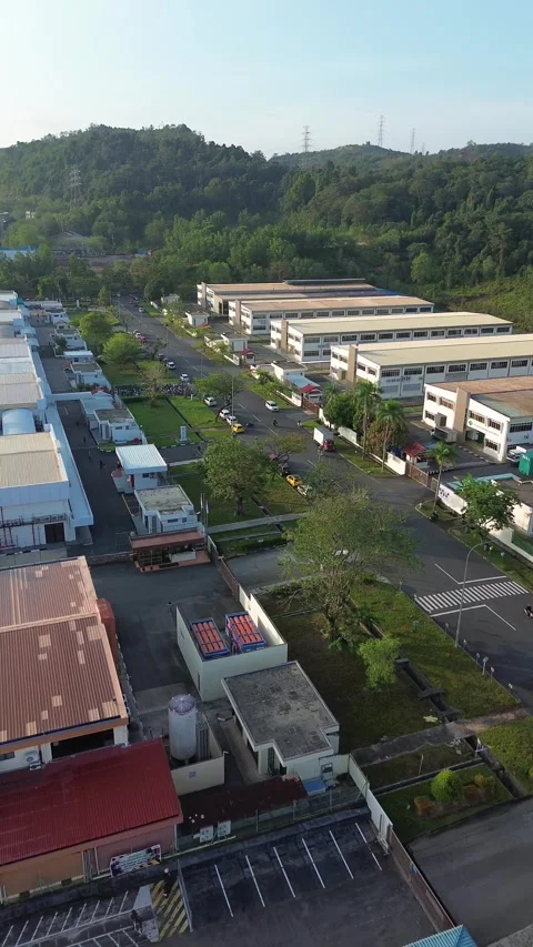 Aerial overview of a sprawling industrial complex nestled amidst green hill.. Video stock 337242979