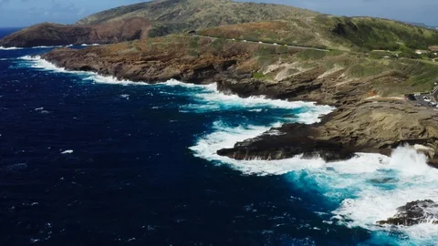 Aerial of Pacific ocean waves crushing into rocky coast of Oahu island Stock Footage 127329189