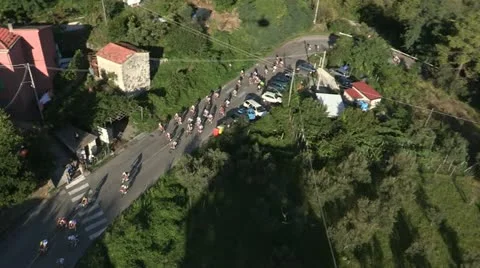 Aerial Pack of cyclists passing through town Stock Footage 22204089