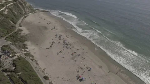 Aerial pan down over waves at the beach on a sunny summer day Stock Footage 157132515
