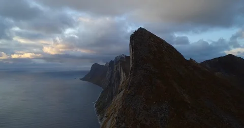 Aerial, pan, drone shot, of the Segla peak and a cloudy sunset above the Stock Footage 123824911