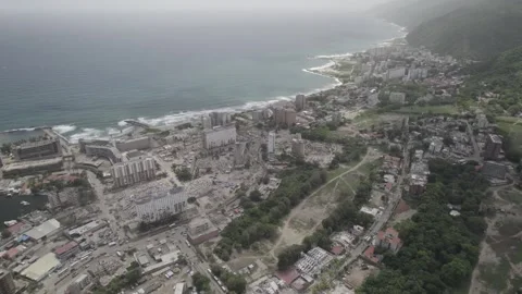 Aerial pan left drone shot over devastated coastal city, marina, and destroyed Stock Footage 341427514