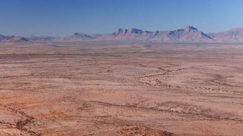 Aerial pan of Namib desert plain and Naukluft style massif, Namibia Stock Footage 341422752
