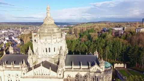 Aerial pan over Basilique Sainte Thérèse de Lisieux with skyline and forest Video stock 328142287