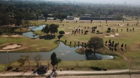 Aerial Pan Over Golf Course That is Surrounded by Nature &amp; Mountains Stock Footage 123737631