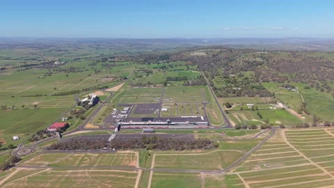 Aerial pan over Mount Panorama Circuit and Bathurst countryside NSW Stock Footage 334927603