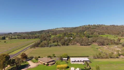 Aerial pan over Mount Panorama Circuit and Bathurst countryside NSW Stock Footage 334927946