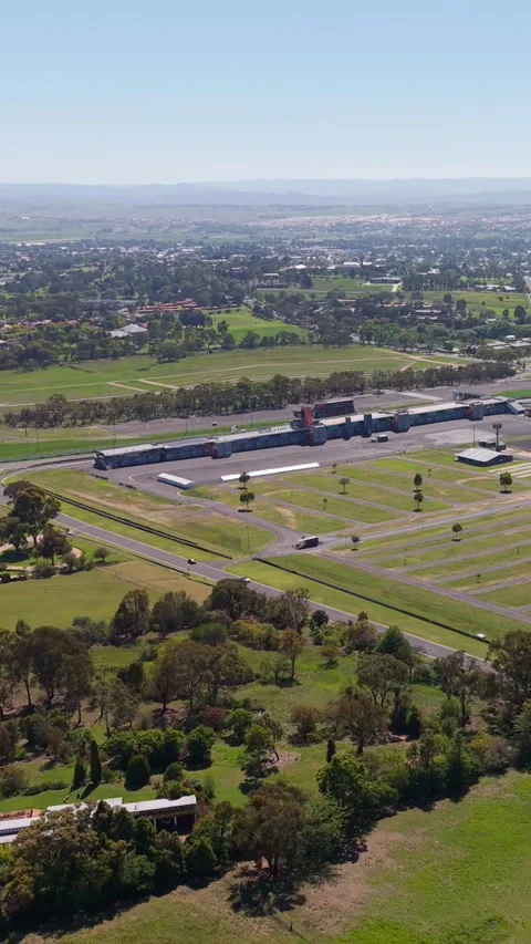 Aerial pan over Mount Panorama Circuit and Bathurst countryside NSW Stock Footage 335000985