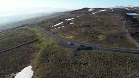 Aerial pan over mountain pass road with snow patches, Fjardarheidi Iceland Stock Footage 346551877