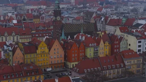 Aerial pan over Wroclaw Old Town Rynek, clock tower and roofs Stock Footage 330899428