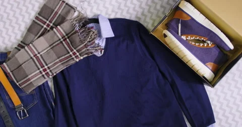 Aerial pan shot of autumn fall clothes and boots outfit laid on a bed Stock Footage 204046594