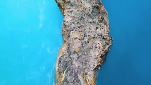 Aerial Pan Shot of Rugged Volcano Crater Cliff and Deep Blue Mineral Water Vidéo 344086909
