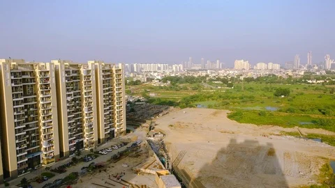Aerial pan from an under construction building to farms, lakes, and grassy Stock Footage 96058848