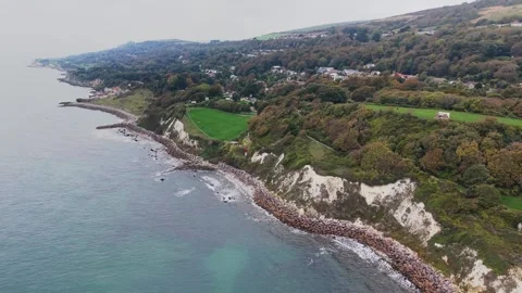 Aerial pan of Ventnor coastal cliffs and rocky coastline, Isle of Wight Stock Footage 337030524