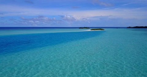 Aerial pan view around a group of tiny tropical islands in the middle of Stock Footage 118242889