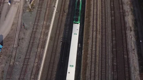 Aerial panning down to watch train pass by directly below as flying forward foll Stock Footage 151935841