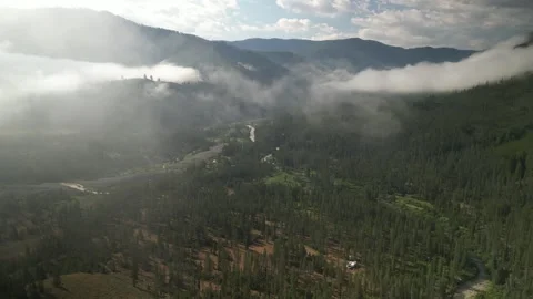Aerial panning on low clouds in Sawtooth mountains near Stanley Idaho in morning Stock Footage 280219042