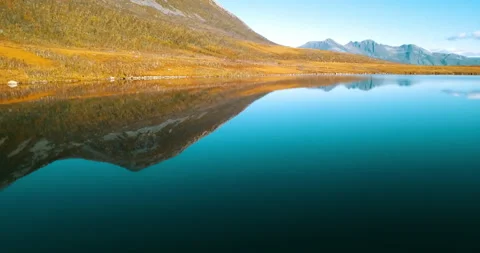 Aerial: Panning Reflection Of Mountain In Tranquil Lake, Drone Flying Forward On Stock Footage 233997179