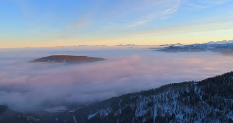 Aerial panning shot of cloudscape around tree mountains against sky during Stock Footage 128845138