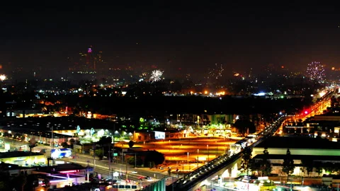 Aerial Panning Shot Of Fireworks Exploding Over Buildings In Suburb, Drone Stock Footage 243880394