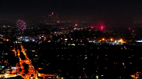 Aerial Panning Shot Of Fireworks Exploding Over Buildings In City At Night, Stock Footage 243883865
